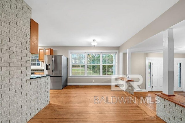 kitchen with stainless steel refrigerator with ice dispenser and light hardwood / wood-style flooring