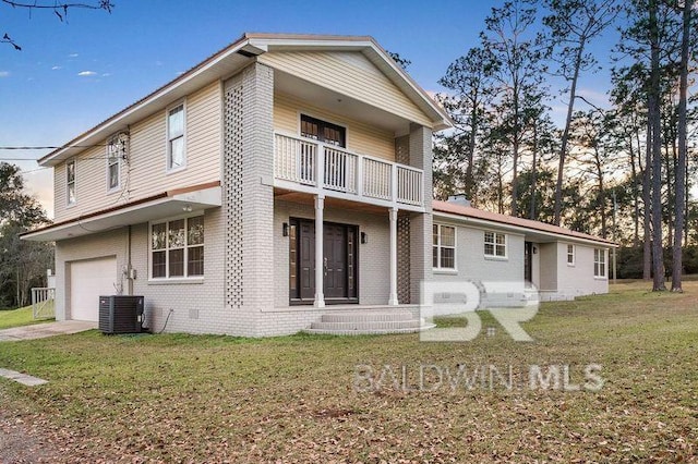 back of house featuring a lawn, cooling unit, a garage, and a balcony