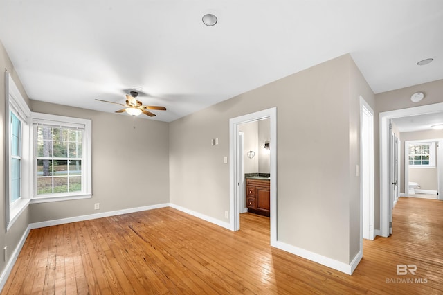 empty room with light hardwood / wood-style flooring, plenty of natural light, and ceiling fan