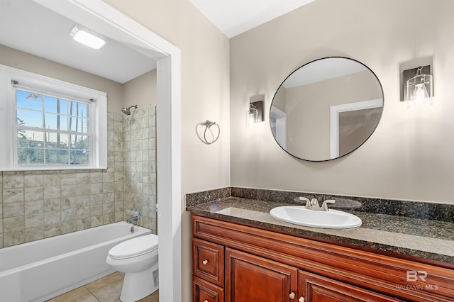 full bathroom featuring tile patterned flooring, vanity, toilet, and tiled shower / bath