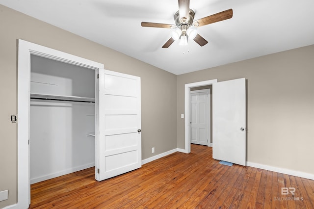 unfurnished bedroom featuring wood-type flooring, a closet, and ceiling fan