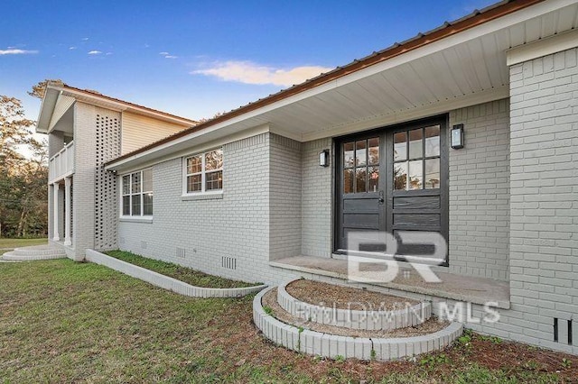 property entrance featuring french doors and a lawn