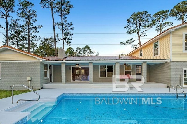 view of swimming pool with ceiling fan and a patio area