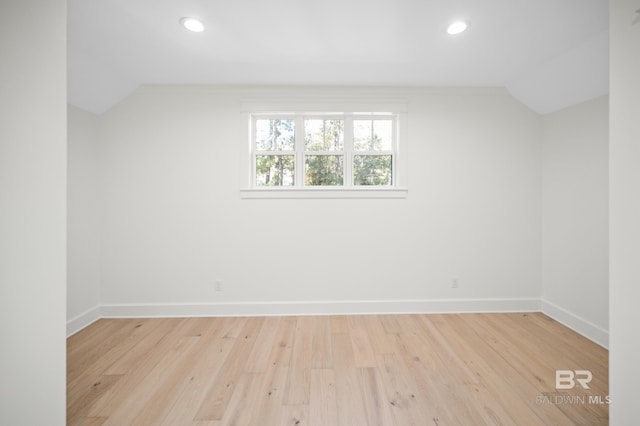 additional living space with light hardwood / wood-style floors and vaulted ceiling