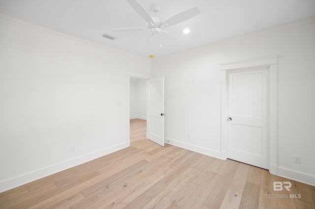 unfurnished room with ceiling fan, light wood-type flooring, and ornamental molding