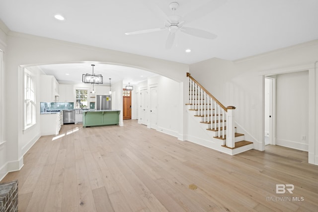 unfurnished living room featuring ceiling fan and light hardwood / wood-style flooring