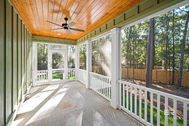 unfurnished sunroom with ceiling fan and wood ceiling