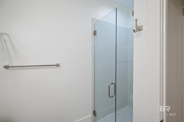 bathroom featuring a shower with door