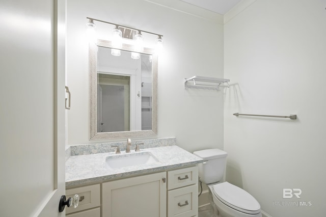 bathroom with vanity, toilet, and crown molding