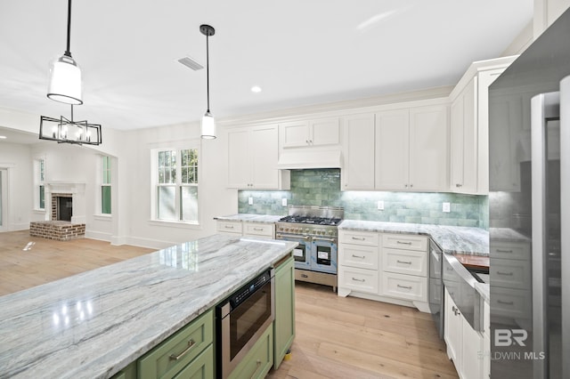 kitchen featuring appliances with stainless steel finishes, light wood-type flooring, and hanging light fixtures