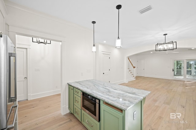 kitchen with light stone countertops, green cabinets, crown molding, appliances with stainless steel finishes, and light wood-type flooring