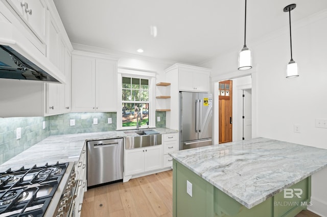 kitchen with pendant lighting, high end appliances, sink, light wood-type flooring, and white cabinetry