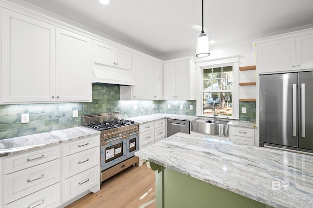 kitchen featuring tasteful backsplash, custom range hood, stainless steel appliances, sink, and white cabinets