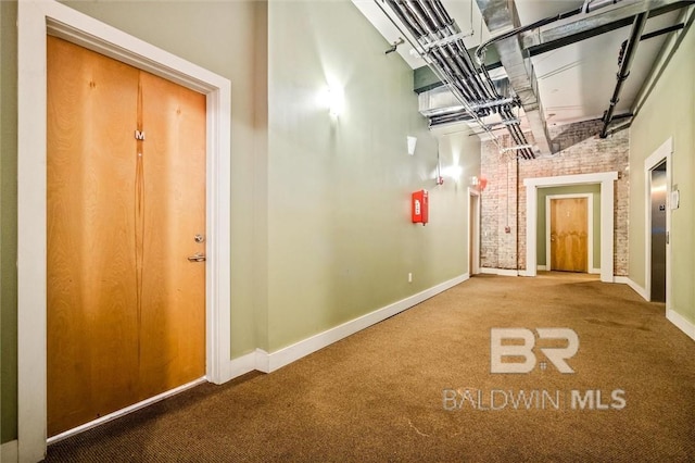 hallway featuring brick wall and carpet