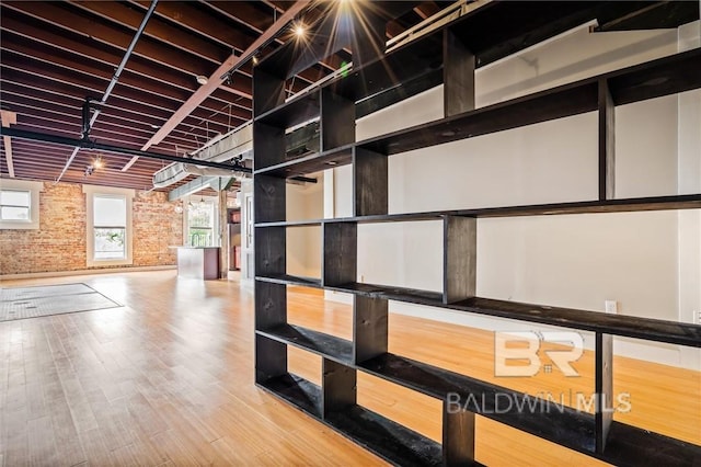 interior space with hardwood / wood-style flooring and brick wall