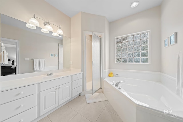 ensuite bathroom featuring tile patterned floors, vanity, ensuite bathroom, and a garden tub