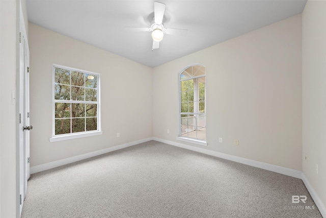 empty room featuring baseboards, carpet floors, and a ceiling fan