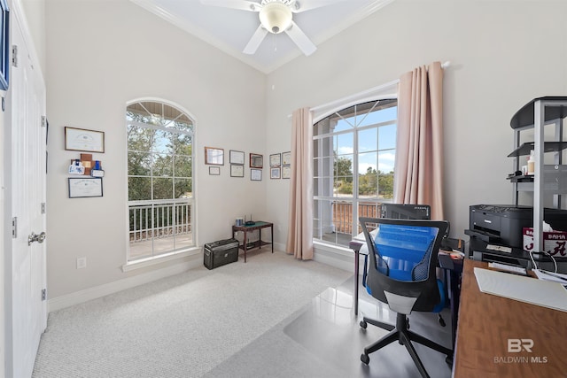 carpeted home office with crown molding, a healthy amount of sunlight, baseboards, and ceiling fan