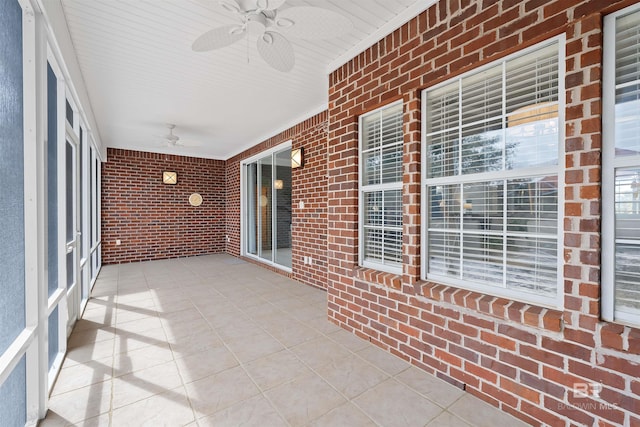 unfurnished sunroom featuring ceiling fan