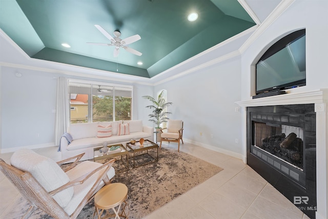 living room featuring tile patterned flooring, baseboards, crown molding, and a tray ceiling