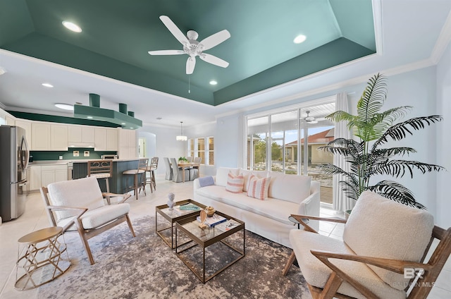 living room with light tile patterned flooring, a raised ceiling, ceiling fan, and crown molding