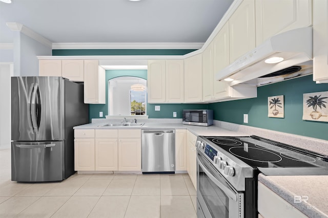 kitchen with a sink, ornamental molding, stainless steel appliances, white cabinets, and under cabinet range hood