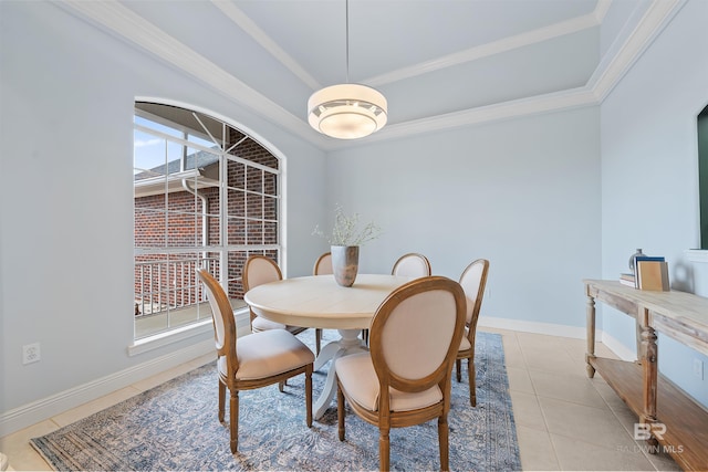 dining area featuring crown molding, light tile patterned floors, baseboards, and a raised ceiling