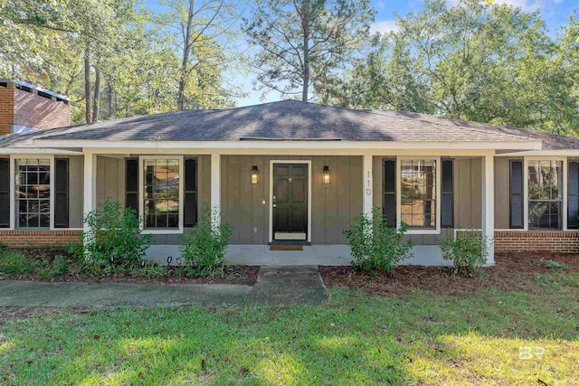 ranch-style house with a front yard and a porch