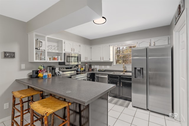 kitchen with a kitchen breakfast bar, kitchen peninsula, sink, and appliances with stainless steel finishes