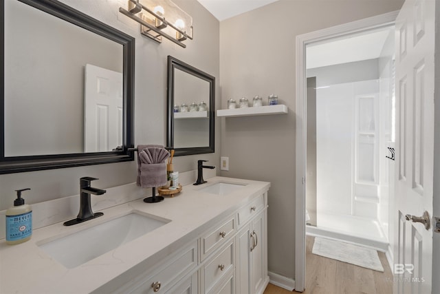 bathroom featuring hardwood / wood-style floors, vanity, and a shower