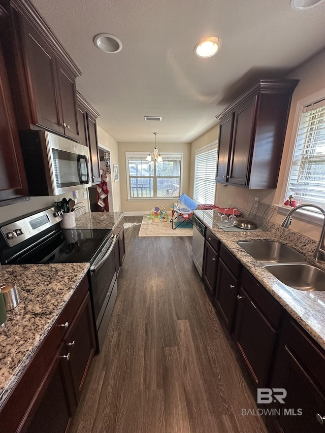 kitchen with an inviting chandelier, sink, hanging light fixtures, dark hardwood / wood-style flooring, and stainless steel appliances