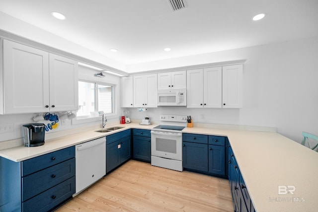 kitchen with blue cabinetry, white appliances, sink, and white cabinets