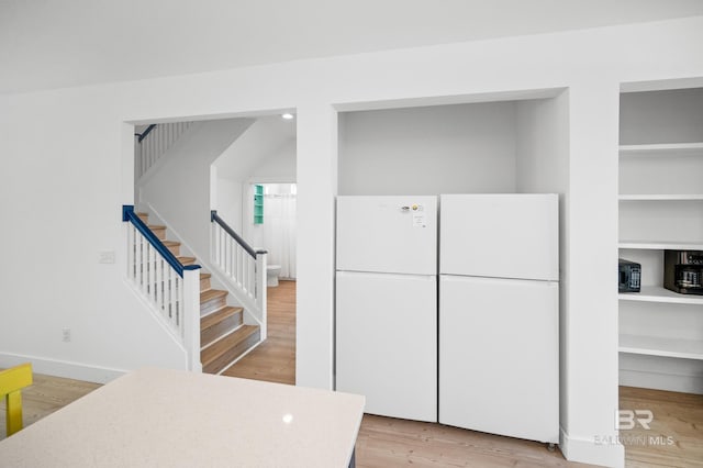 kitchen with light hardwood / wood-style floors and white fridge