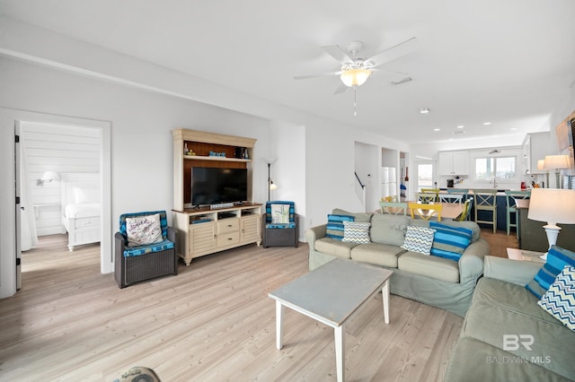 living room with ceiling fan and light hardwood / wood-style floors