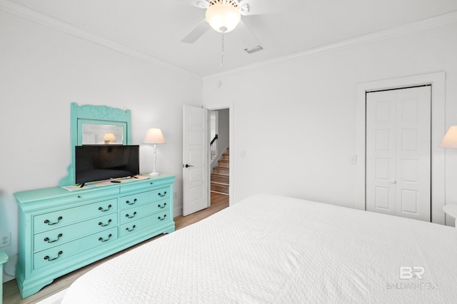 bedroom featuring hardwood / wood-style floors, ornamental molding, a closet, and ceiling fan