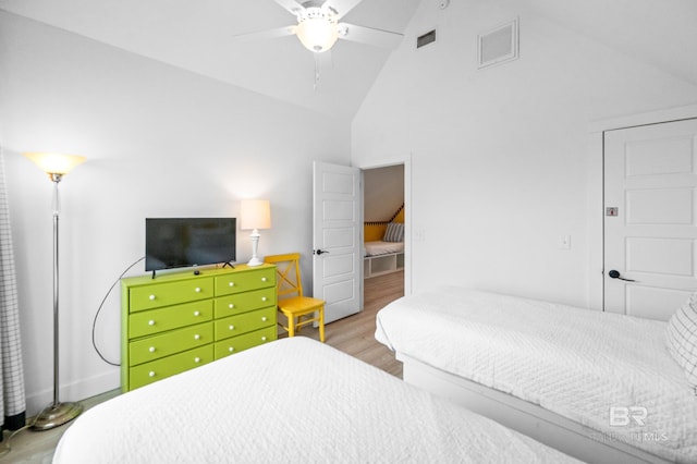 bedroom with wood-type flooring, high vaulted ceiling, and ceiling fan