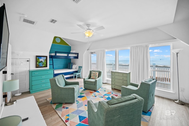 living room with vaulted ceiling, light hardwood / wood-style floors, and ceiling fan