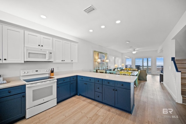 kitchen with blue cabinets, light hardwood / wood-style flooring, kitchen peninsula, white appliances, and white cabinets