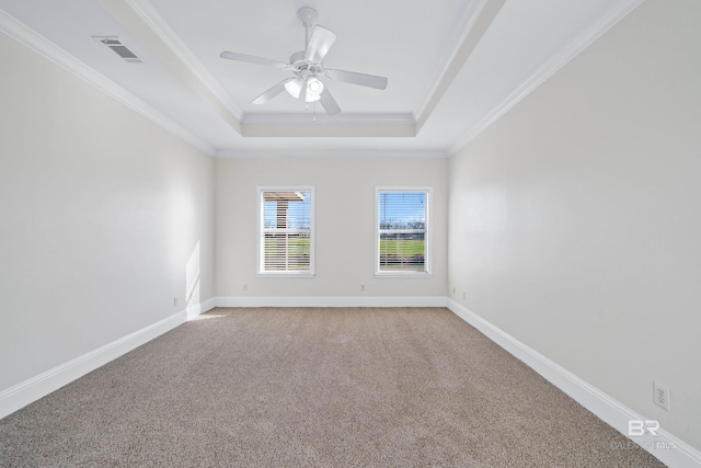 spare room with ornamental molding, carpet floors, a tray ceiling, and ceiling fan