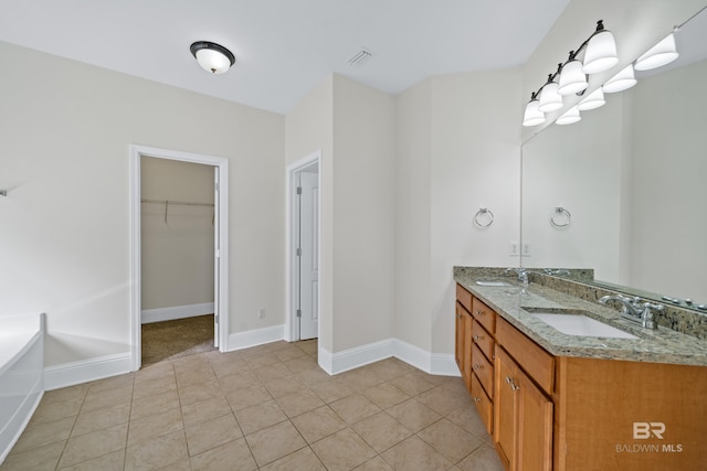 bathroom with vanity, tile patterned flooring, and a bath