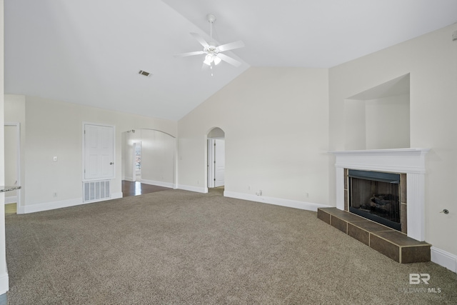 unfurnished living room featuring ceiling fan, a tile fireplace, high vaulted ceiling, and carpet flooring