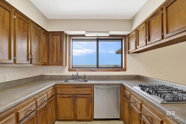 kitchen with a sink, brown cabinetry, and stainless steel appliances