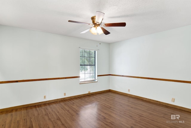 spare room with a ceiling fan, baseboards, and wood finished floors