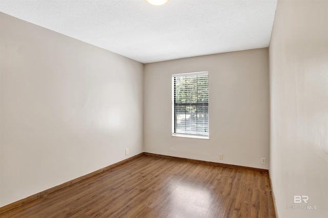 unfurnished room with baseboards and wood finished floors