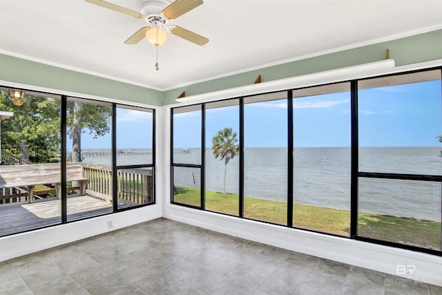 unfurnished sunroom featuring crown molding, a water view, and stone finish floor