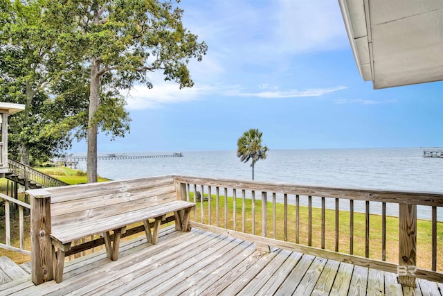 wooden deck featuring a lawn and a water view