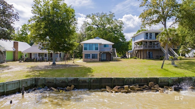 rear view of property with a deck with water view, a yard, and stairway