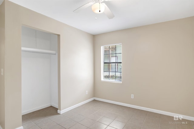 unfurnished bedroom with baseboards, a ceiling fan, a closet, and light tile patterned flooring