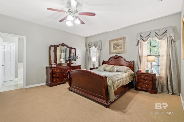 bedroom featuring ceiling fan, light carpet, and ensuite bathroom