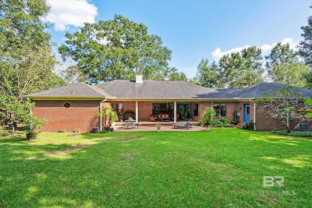 rear view of property with a yard and a patio